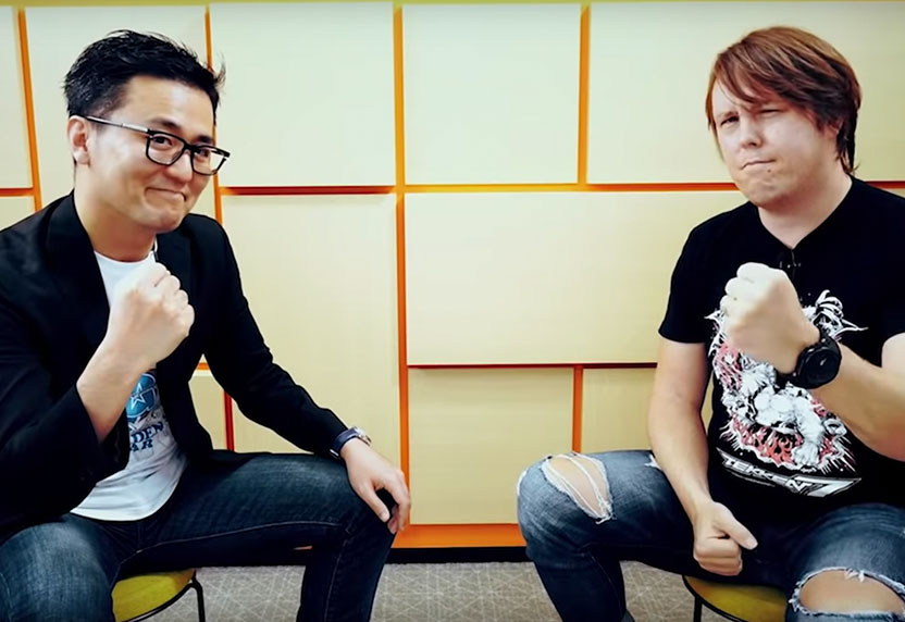 《铁拳 7》 游戏总监池田幸平和制片人迈克尔·默里坐在一起，各自握着一个拳头。