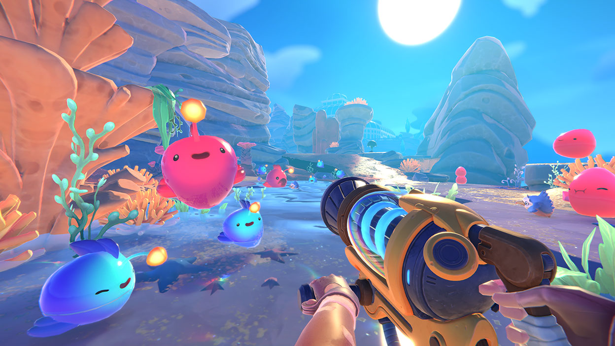 From a first person point of view, Beatrix LeBeau aims the barrel of her Vacpack towards a group of cheerful anglerfish slimes.