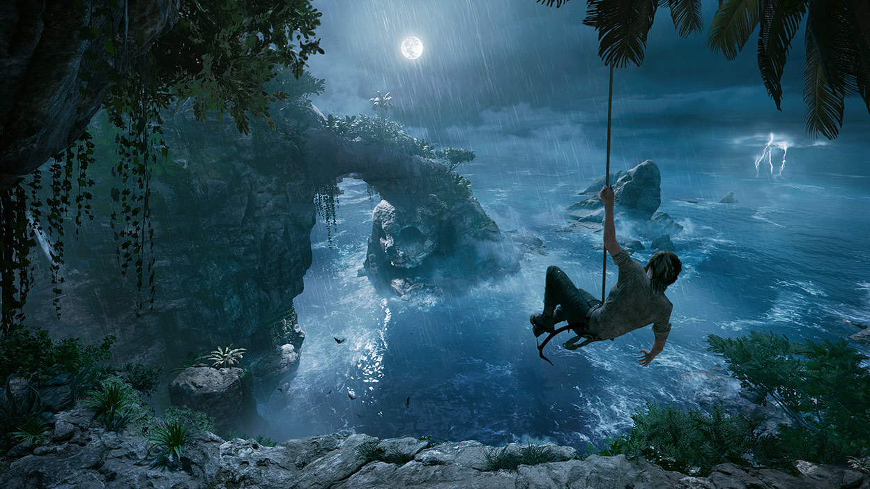 Lara Croft swings from a vine over water on a jungle island