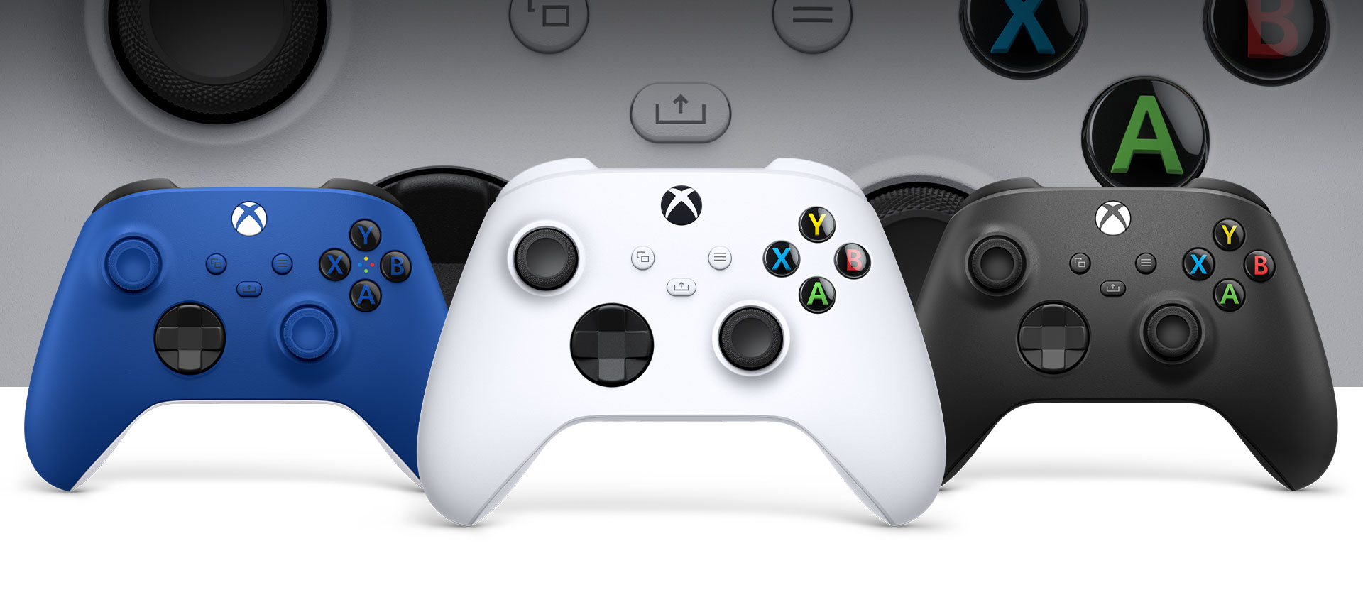 Xbox Robot White -ohjain edessä, Xbox Carbon Black- ja Shock Blue -ohjaimet sen vieressä