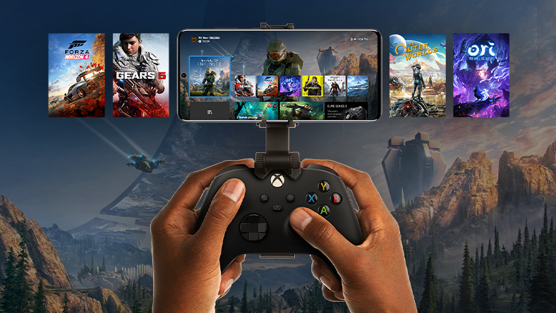Μια κινητή συσκευή συνδεδεμένη με ένα χειριστήριο Xbox, παρουσιάζοντας μια επιλογή τίτλων παιχνιδιών. Ο κόσμος του Halo Infinite εκτείνεται πέρα από το τηλέφωνο.