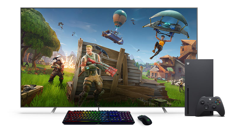 Un clavier et une souris noirs devant une Xbox Series X