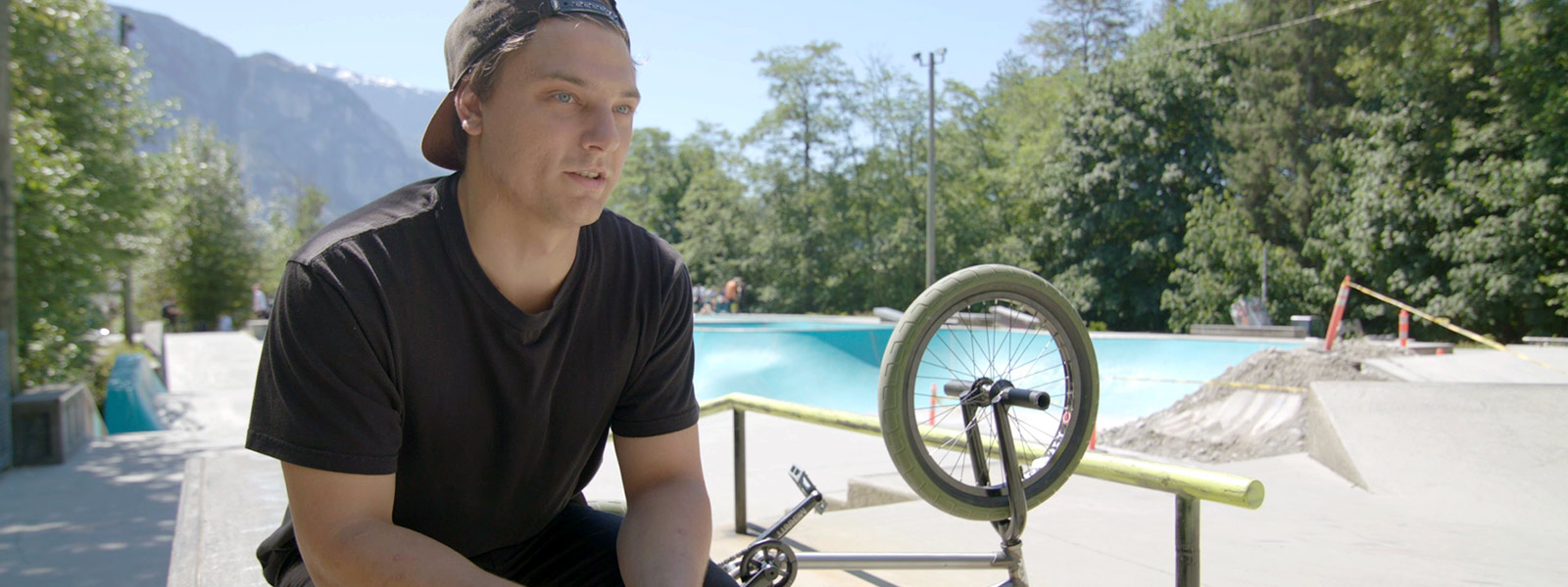 Matt Jensen sits in front of his BMX bike at a skate park, a major source of inspiration for making games.